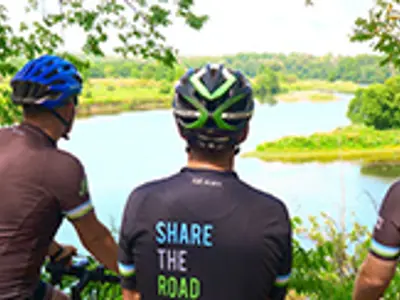 three cyclists look over the grand river